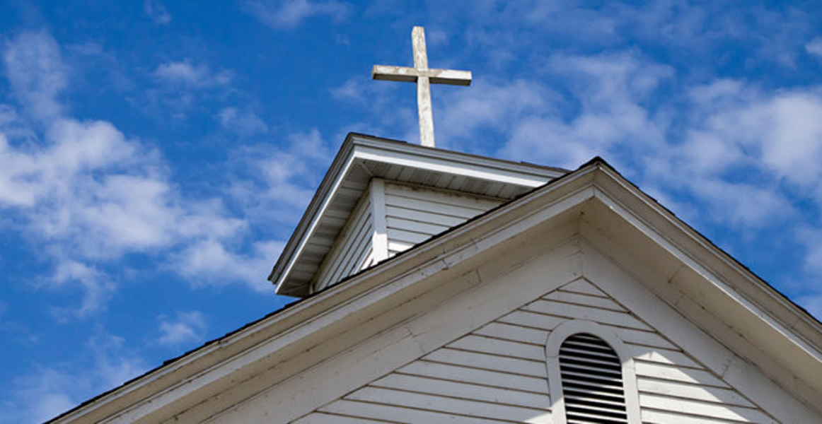 教堂建筑顶上的十字架的照片