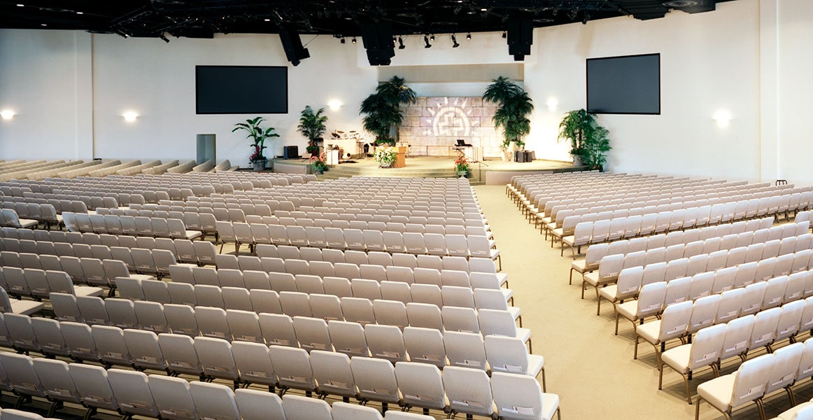 Inquadratura in ampia scala di file di sedie Bertolini in una sala di culto