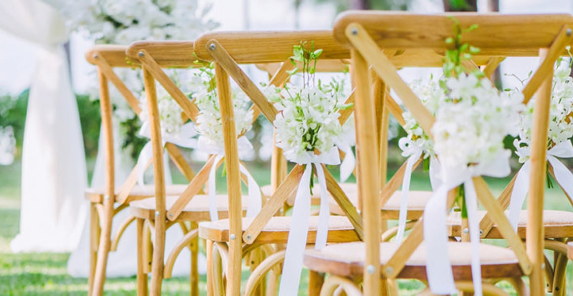 Rows of wedding chairs decorated with bows