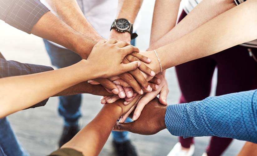 Cerchio di persone con le mani al centro