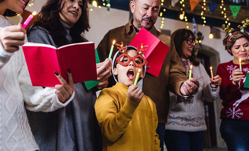 gruppo di giovani famiglie e amici che cantano canti natalizi