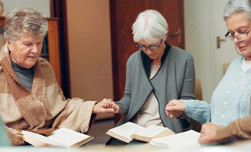 Group of seniors in prayer at a study session