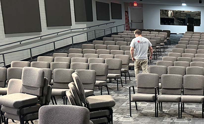 Church employee arranging chairs