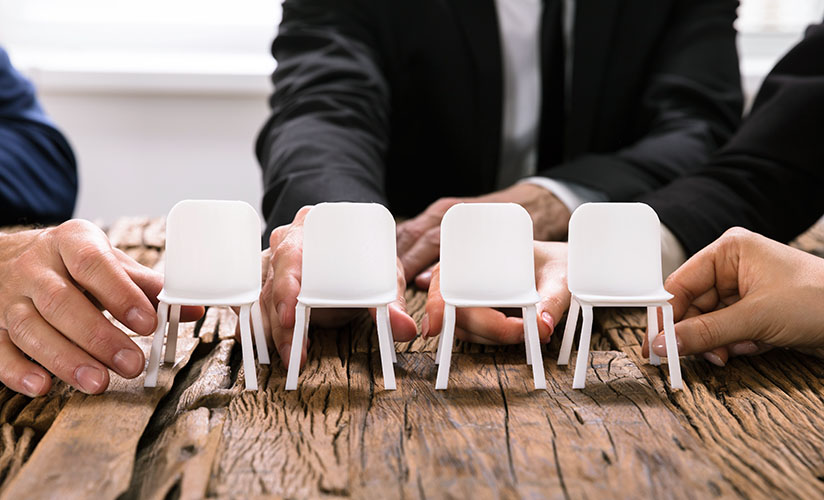 hands arranging small plastic chairs