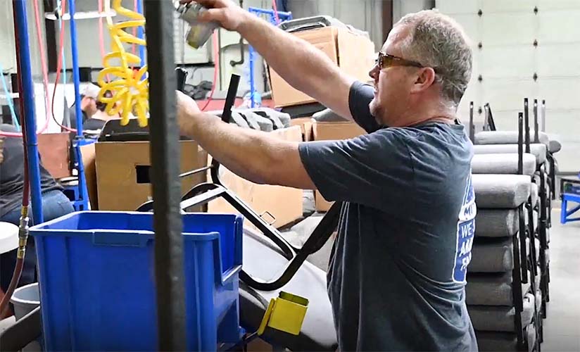 Manufacturing employee installing glides to a Bertolini chair frame