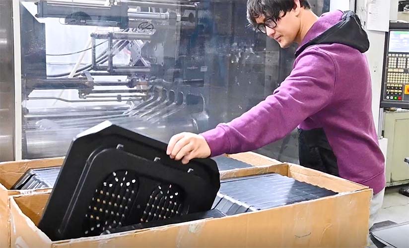 Manufacturing employee placing a seat base into a box