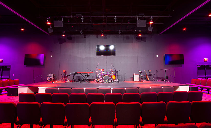 Bertolini chairs in front of a stage lit in red