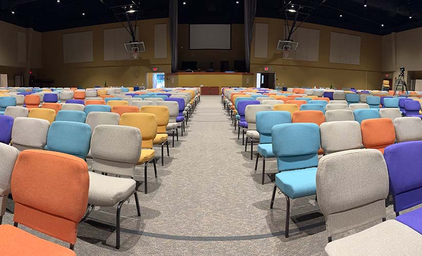 An open aisle way flanked by vibrant Impressions chairs at Bethany Wesleyan Church